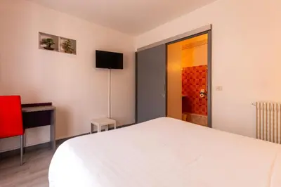 Un ou plusieurs lits dans un hébergement de l'établissement Hôtel Le Cheval Blanc