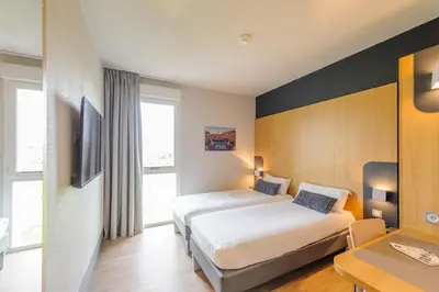 Un ou plusieurs lits dans un hébergement de l'établissement B&B HOTEL La Rochelle Beaulieu Puilboreau