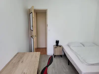 Un ou plusieurs lits dans un hébergement de l'établissement Chambre dans meublé tout équipé