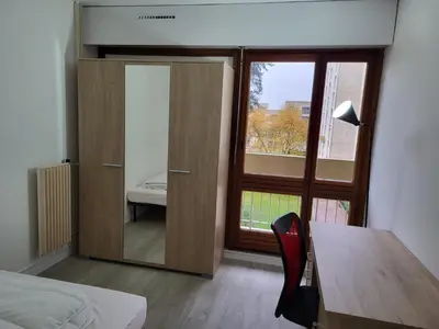 Un ou plusieurs lits dans un hébergement de l'établissement Chambre dans meublé tout équipé