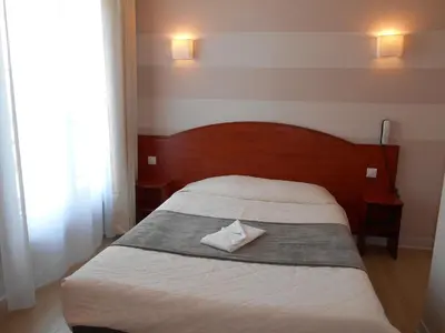 Un ou plusieurs lits dans un hébergement de l'établissement Hôtel Le Rupella