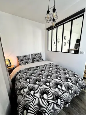 Un ou plusieurs lits dans un hébergement de l'établissement Joli appartement avec parking