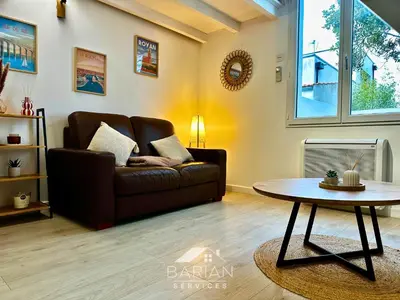 Coin salon dans l'établissement Maisonnette avec climatisation et cour - ménage et linge inclus
