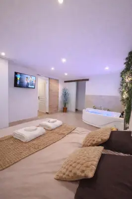 Un ou plusieurs lits dans un hébergement de l'établissement Logement entier avec jacuzzi proche futuroscope