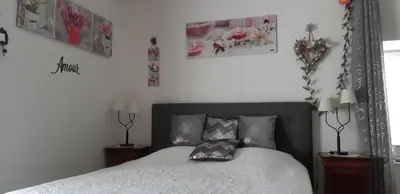 Un ou plusieurs lits dans un hébergement de l'établissement Chambre d'Hôtes Les Orchidées FUTUROSCOPE CHASSENEUIL POITIERS