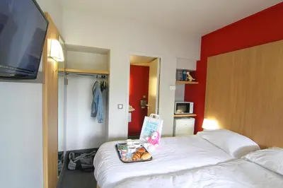 Un ou plusieurs lits dans un hébergement de l'établissement Kyriad Direct Poitiers - Gare du Futuroscope