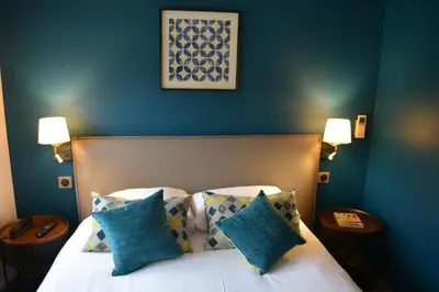 Un ou plusieurs lits dans un hébergement de l'établissement Logis hotels Les Glycines