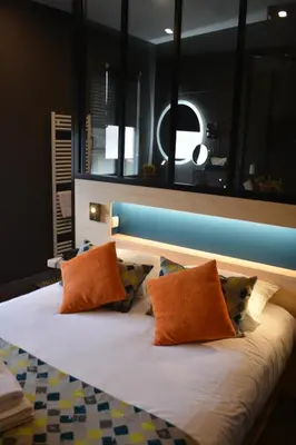 Un ou plusieurs lits dans un hébergement de l'établissement Logis hotels Les Glycines