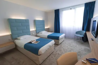Un ou plusieurs lits dans un hébergement de l'établissement Hotel Plaza - site du Futuroscope