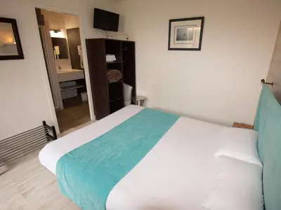 Un ou plusieurs lits dans un hébergement de l'établissement Cit'Hotel Les Eleis