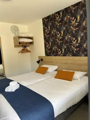 Un ou plusieurs lits dans un hébergement de l'établissement Cit'Hotel Les Eleis
