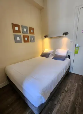 Un ou plusieurs lits dans un hébergement de l'établissement Logis Hôtel Lafayette Rochefort France
