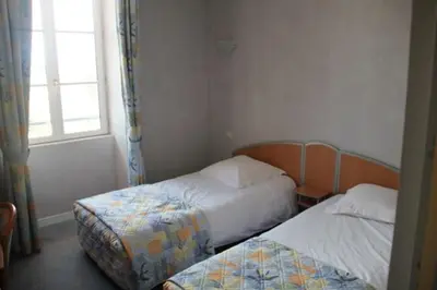 Un ou plusieurs lits dans un hébergement de l'établissement Logis Hôtel de France restaurant le Lucullus