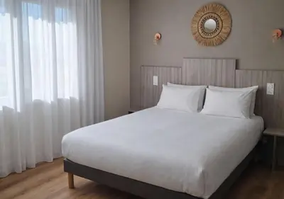 Un ou plusieurs lits dans un hébergement de l'établissement Kyriad Angoulême Nord Champniers- Hôtel & Résidence