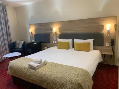 Un ou plusieurs lits dans un hébergement de l'établissement Brit Hotel Bleu Nuit