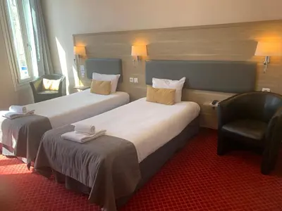 Un ou plusieurs lits dans un hébergement de l'établissement Brit Hotel Bleu Nuit
