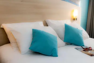 Un ou plusieurs lits dans un hébergement de l'établissement Brit Hotel La Rochelle Périgny