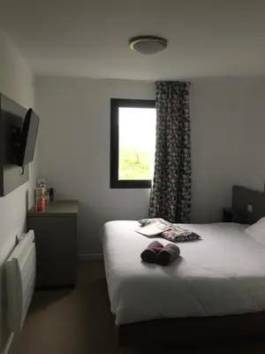 Un ou plusieurs lits dans un hébergement de l'établissement Kyriad Direct La Rochelle Aytré