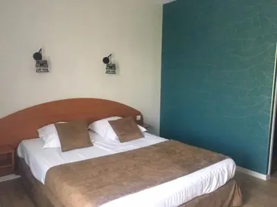 Un ou plusieurs lits dans un hébergement de l'établissement LOGIS Hôtel LES 3 MARCHANDS
