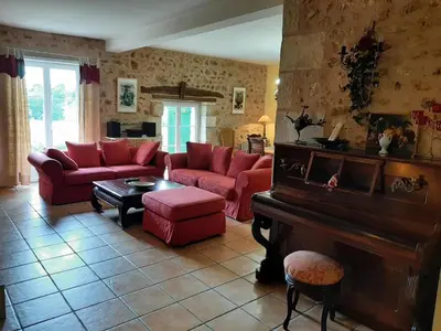 Coin salon dans l'établissement Gîte La Queue Rousse - Maison Ancienne avec Cheminée et Jardin Clôturé - FR-1-653-132