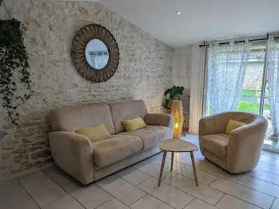 Coin salon dans l'établissement Maison charentaise avec piscine chauffée, jardin privé et proche commerces, idéale pour couples - FR-1-653-228