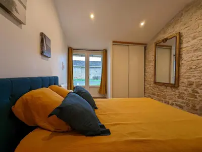 Un ou plusieurs lits dans un hébergement de l'établissement Maison charentaise avec piscine chauffée, jardin privé et proche commerces, idéale pour couples - FR-1-653-228