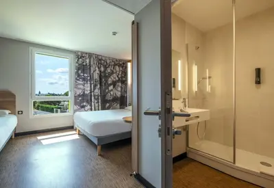 Un ou plusieurs lits dans un hébergement de l'établissement B&B HOTEL Saintes